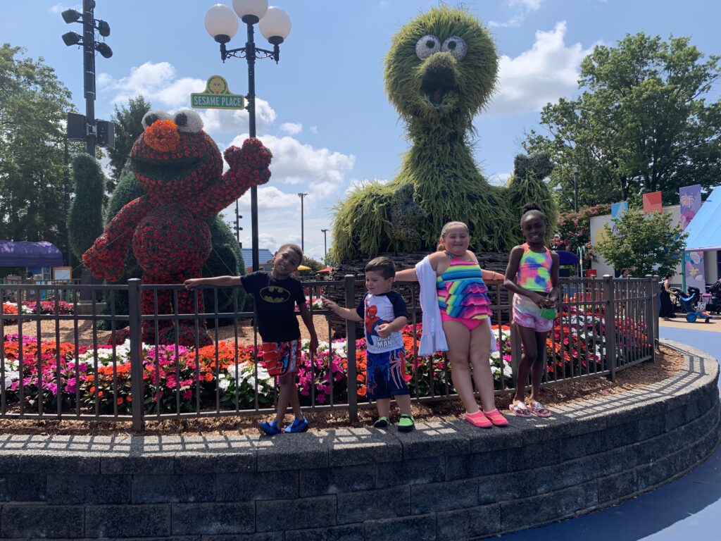 Take a picture in front of Sesame Place display. 